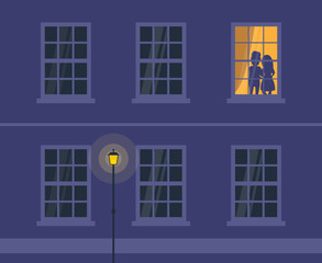loving couple silhouettes in lighting window house facade at night