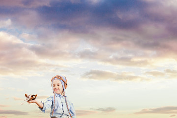 Little boy pilot in the sunset sky