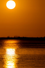 Fototapeta na wymiar Die untergehende Sonne spiegelt sich im ruhigen Wasser der Lagune vor Le Morne, Mauritius, Afrika.