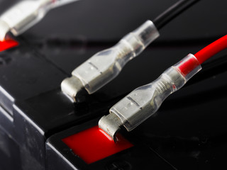 Terminal connectors and wire coming out from an industrial battery. Shallow depth of field.