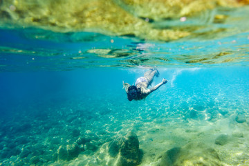 Fototapeta na wymiar Young woman snorkeling and diving in tropical sea