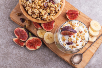 Granola with yogurt, bananas and figs. Copy space