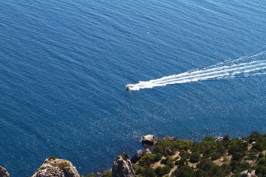 Small boat on blue waves in the sea on summer day, photo of nature - creative image