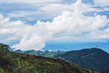 The mountain has a natural green tree in the rainy season and foggy blue sky in Thailand at Phu Tupberk.