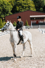 beautiful female equestrian riding horse at horse club