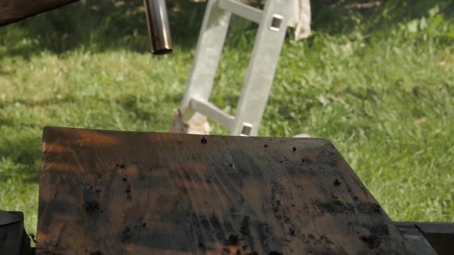 carpenter restoring old furniture. cleaning from old paint with fire. slow motion