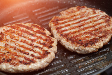 Grilled hamburger cutlets or burger patties on frying pan
