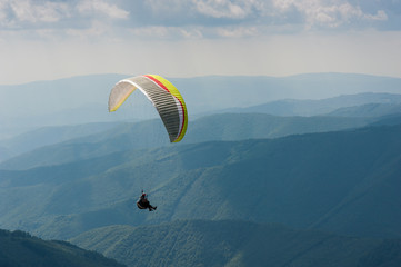 Paraglider takes off from the mountainside in the Carpathian Mountains. Paragliding in the...