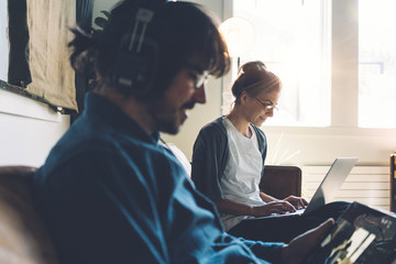 Obraz premium Coworkers in studio together, using digital devices and laptops