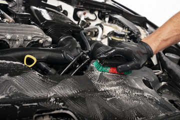 Car detailing maintaince, cleaning engine with the foam and a brush