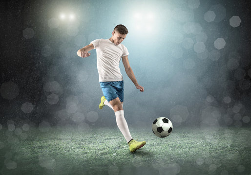 Soccer player on a football field in dynamic action at summer day