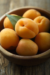 Fresh apricots in the wooden bowl