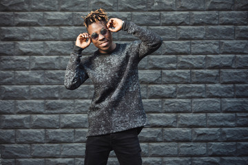 African american man model wear stylish fashionable pullover standing against brick wall