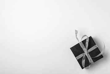 Gift black box with silver ribbon on white background. Top view, copy space