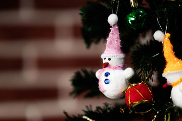 White snowman doll hanging on fake pine tree decorated in home. Concept for big festival merry christmas and happy new year