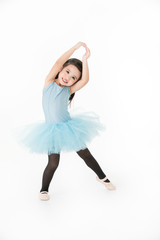 Cute Asian girl in light blue dress preforming ballet with smiling face, isolated on white...