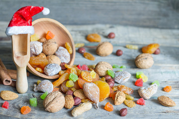 Christmas Santa Claus hat with dried fruits and nuts on wooden background
