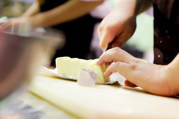 chef cutting butter in kitchen, Cutting butter with a knife in closeup