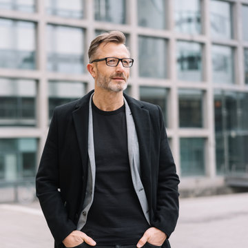 Street portrait of mature man wearing black coat