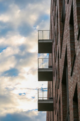 Neubau Fassade mit eckigen Balkonen und Backsteinwand
