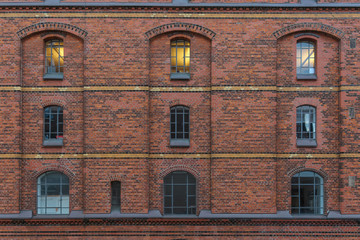 Fassade in der histori8schen Speicherstadt in Hamburg mit einem beleuchteten Fenster