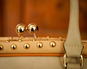 Handtasche mit Kugelverschluss und Nieten in rose Gold. Detail Aufnahme mit Copy Space. 