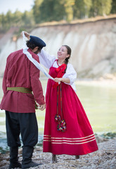 A couple dancing folk dances in Russian national costumes