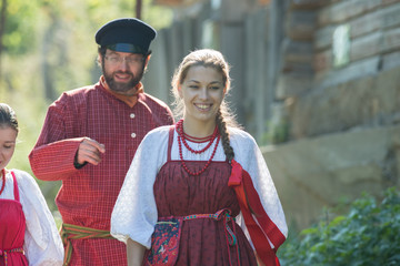 Man and woman in russian folk costumes in nature. Celebration