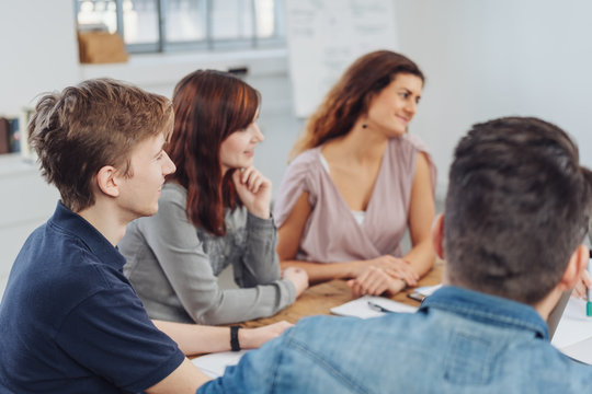 Three young people listening in a meeting