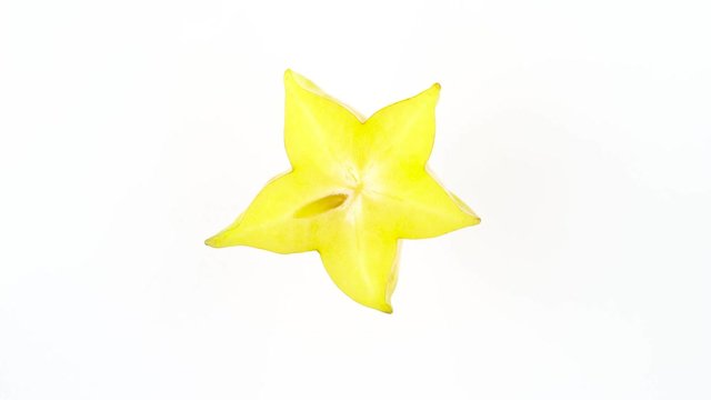 Top view of ripe carambola fruit slice. Cross section. Rotating on the turntable isolated on the white background. Close-up. Macro.