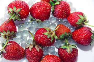 Obraz na płótnie Canvas red berries strawberries and glass balls on a white background