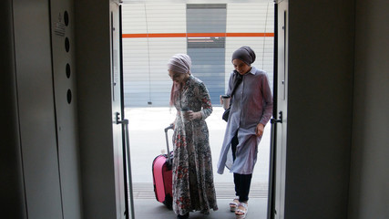 Two muslim girls walking into the train