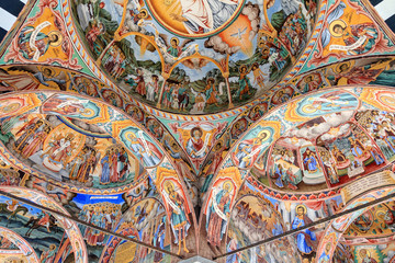 Fototapeta na wymiar Beautiful view of the vibrant decoration of the Orthodox Rila Monastery, a famous tourist attraction and cultural heritage monument in the Rila Nature Park mountains in Bulgaria