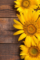 Beautiful yellow sunflowers close-up on a brown wooden table. top view