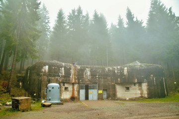 Techonin, Czech Republic / Europe - Nov. 18 2016: Concrete artillery fortification called Bouda standing in deep woods in Eagle Mountains, part of Czechoslovakian fortification, dark foggy fall day