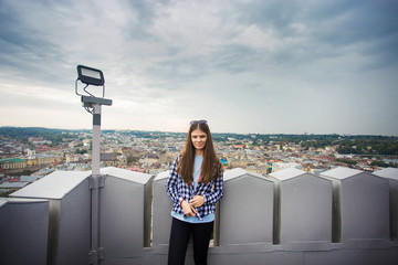 Fototapeta na wymiar Tourist girl on top of european city hall with dramatic sky