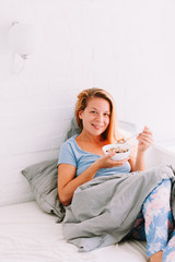 Young woman eating breakfast in bed