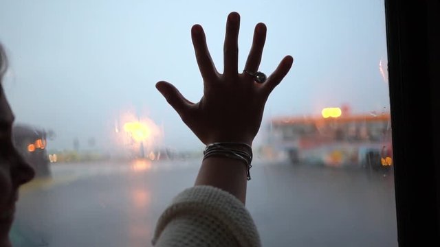 Loneliness on city, woman hand touch window with a rain drops on city background. Find a solution,way out to the problem,