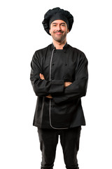 Chef man In black uniform keeping the arms crossed in frontal position. Confident expression on isolated white background