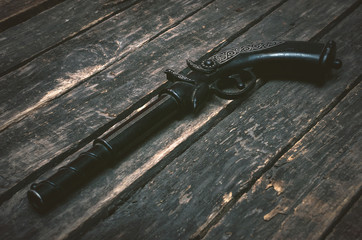 Retro musket gun on wooden table background with copy space.