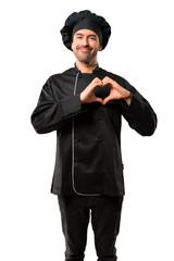 Chef man In black uniform making heart symbol by hands. Being in love on isolated white background