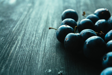 many fresh plums on black background close up