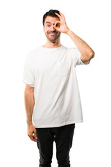 Young man with white shirt makes funny and crazy face emotion on isolated white background