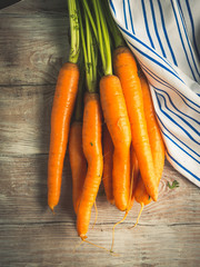 Raw carrots on rustic wooden background. Cooking vegetables