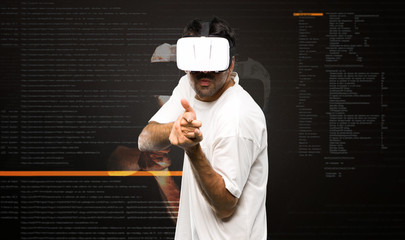 Naklejka premium Man using VR glasses shooting with a virtual pistol inside the virtual reality mode
