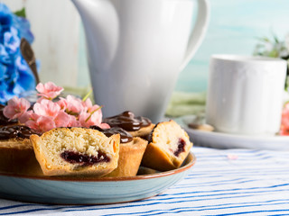 Cakes with frangipane, cherry jam and chocolate frosting. Romantic table setting with flowers. Mother's day card