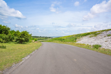 Fototapeta na wymiar Landscape Scenic road travel on empty highway near a large reservoir with sky and clouds background.Pa Sak Jolasid Dam Thailand.
