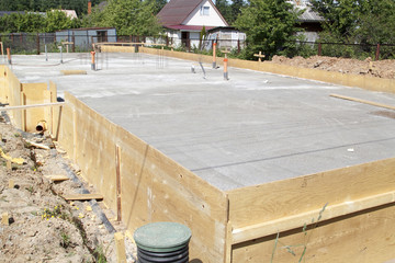 inspection well, trench and concrete slab of foundation with wooden formwork