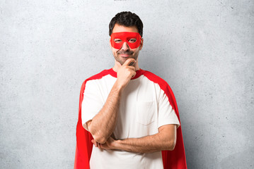 Superhero man with mask and red cape smiling and looking to the front with confident face on...