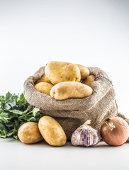 Potatoes in old sack from celery onion and garlic.